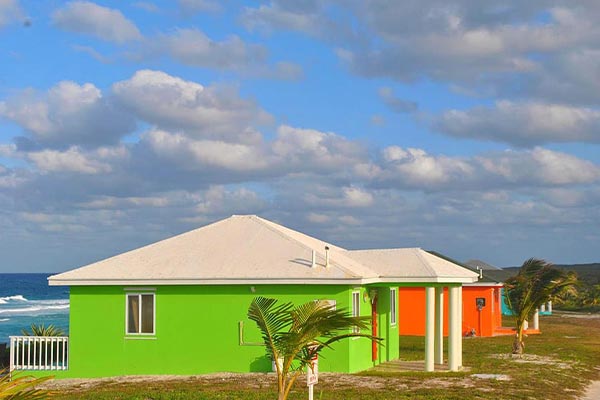 Two brightly colored houses next to the ocean, offering daily freight services to the Bahamas.