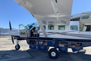 A small airplane parked on the tarmac, offering air freight services to the Bahamas.