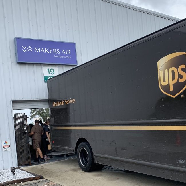 A UPS truck is parked in front of a building, offering daily freight services to the Bahamas.