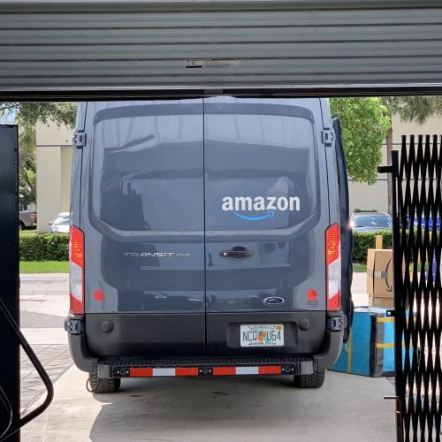 An Amazon transit van parked in a garage, offering daily freight services to the Bahamas.